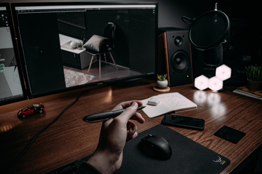 man holding pen under light behind monitors